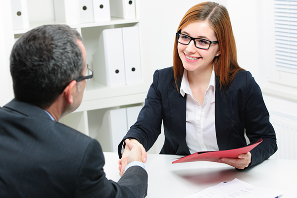 A diverse group of young professionals engaged in a business meeting inside a modern office.